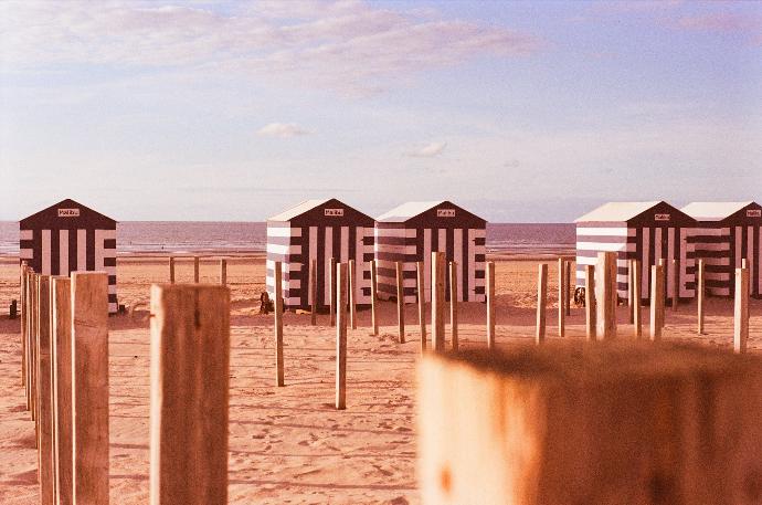a row of beach huts sitting on top of a sandy beach